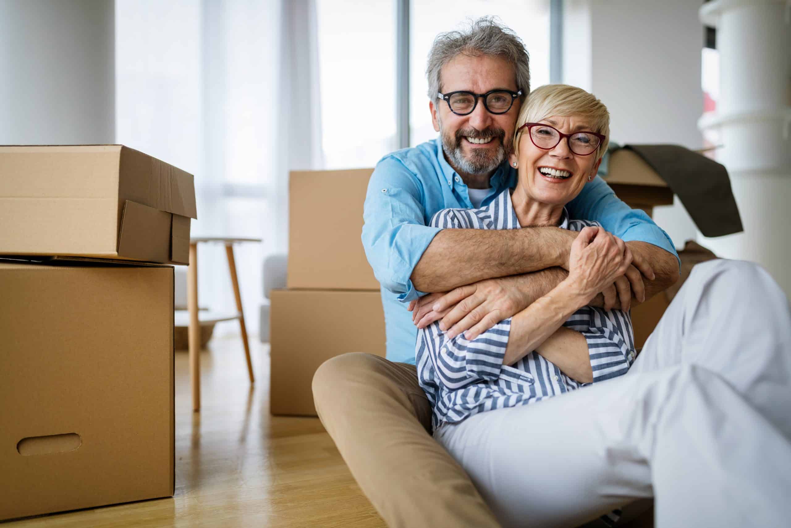 Man and woman sitting next to moving boxes
