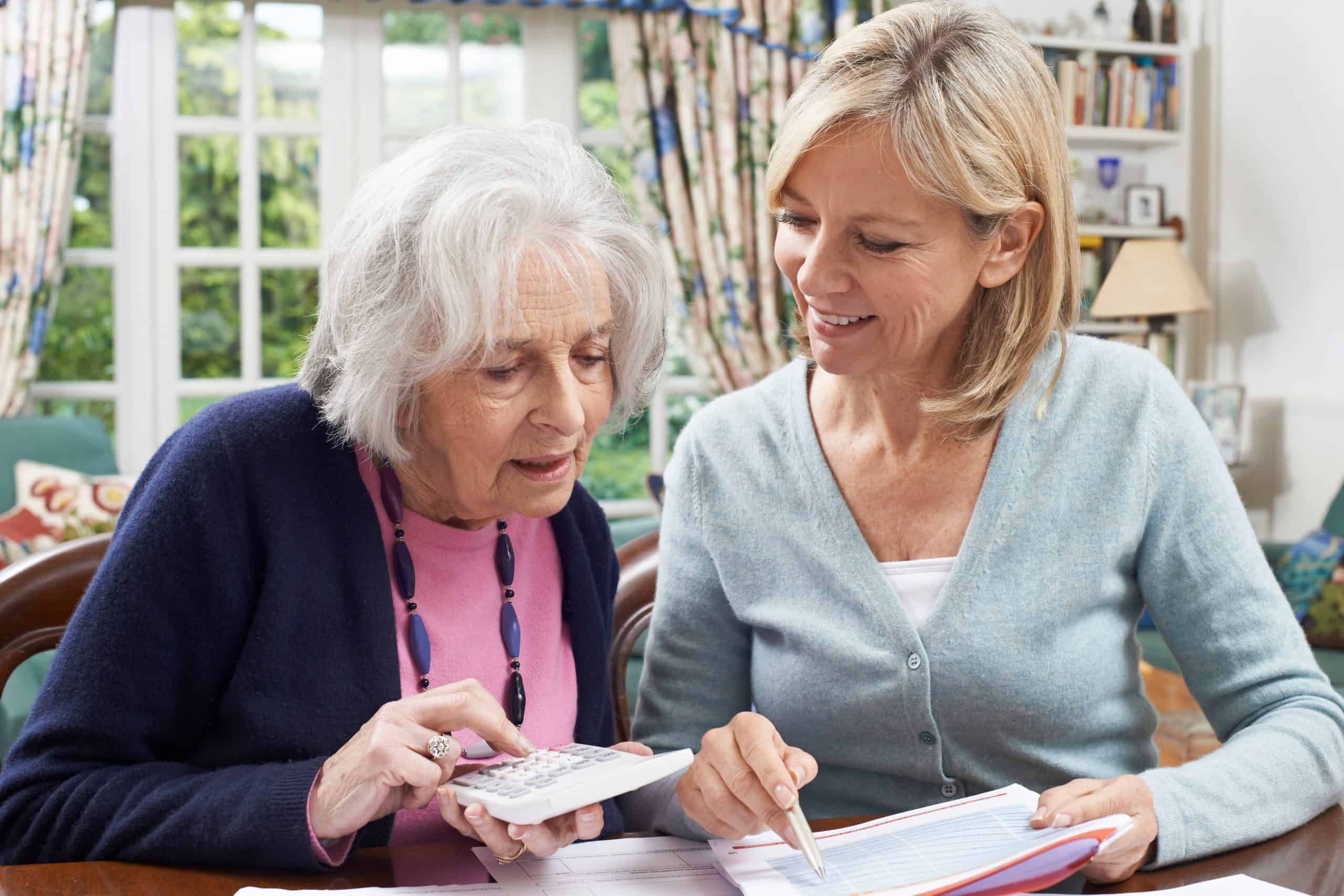 Female neighbor helping senior woman with domestic finances