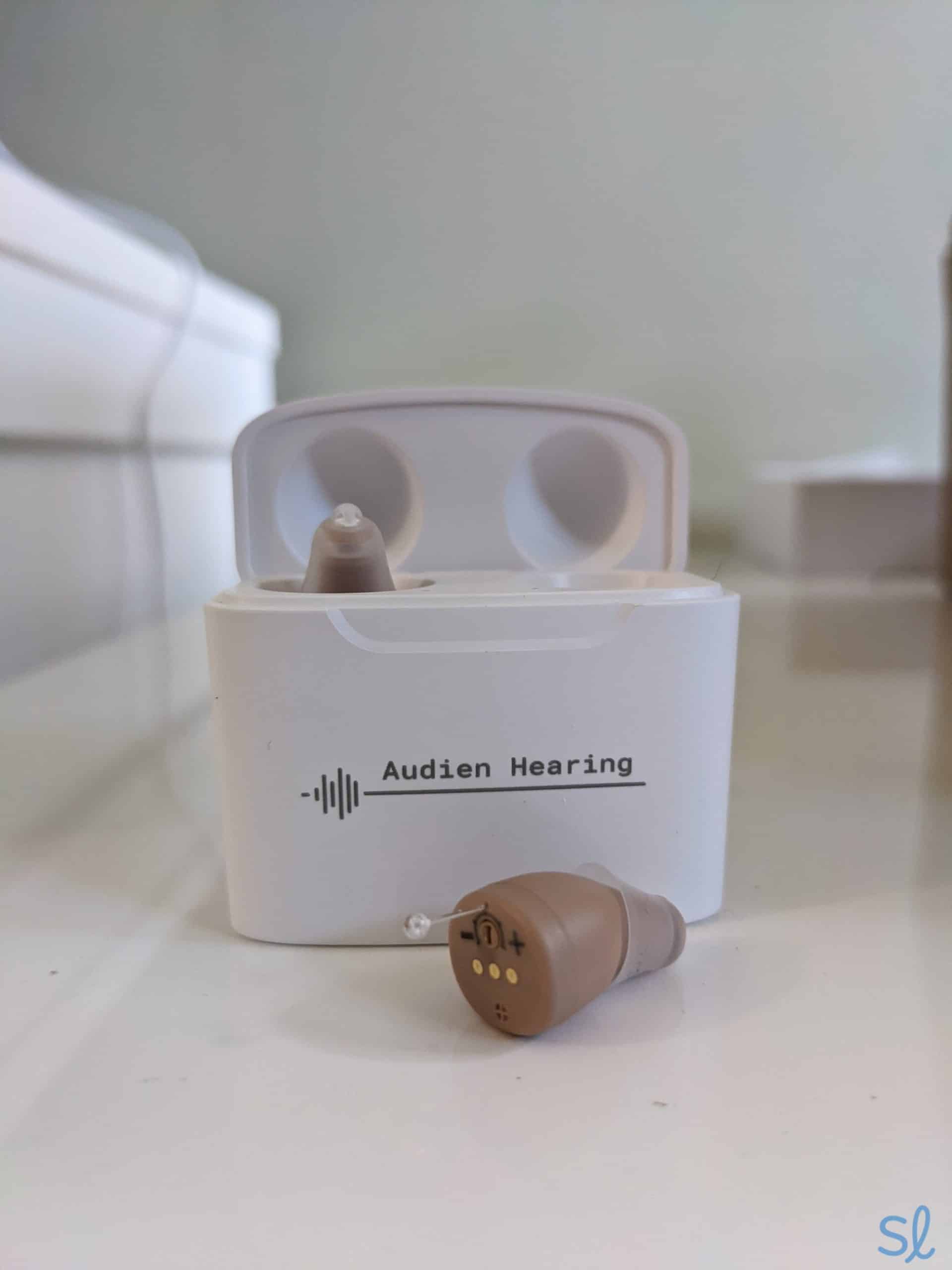 Audien Atom Pro hearing aids inside and outside of the portable charging case