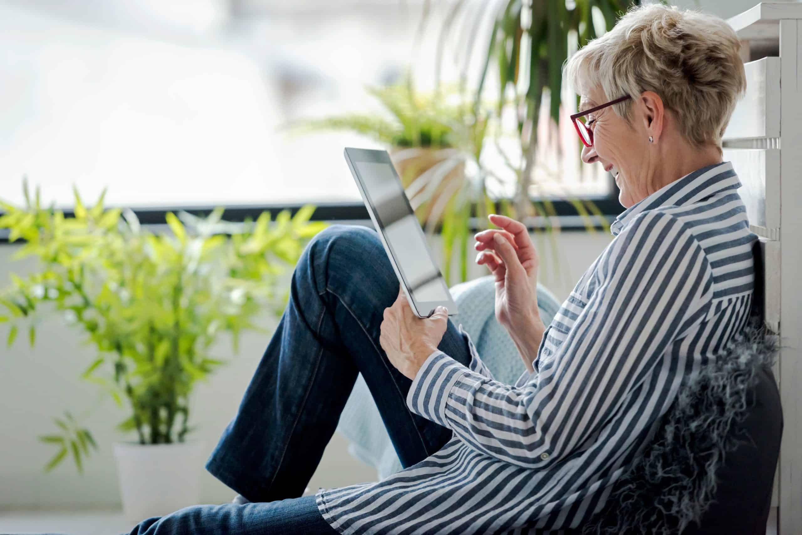 Senior woman using digital tablet at home