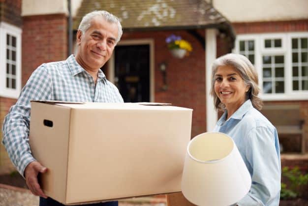 Man holding box and woman holding lamp