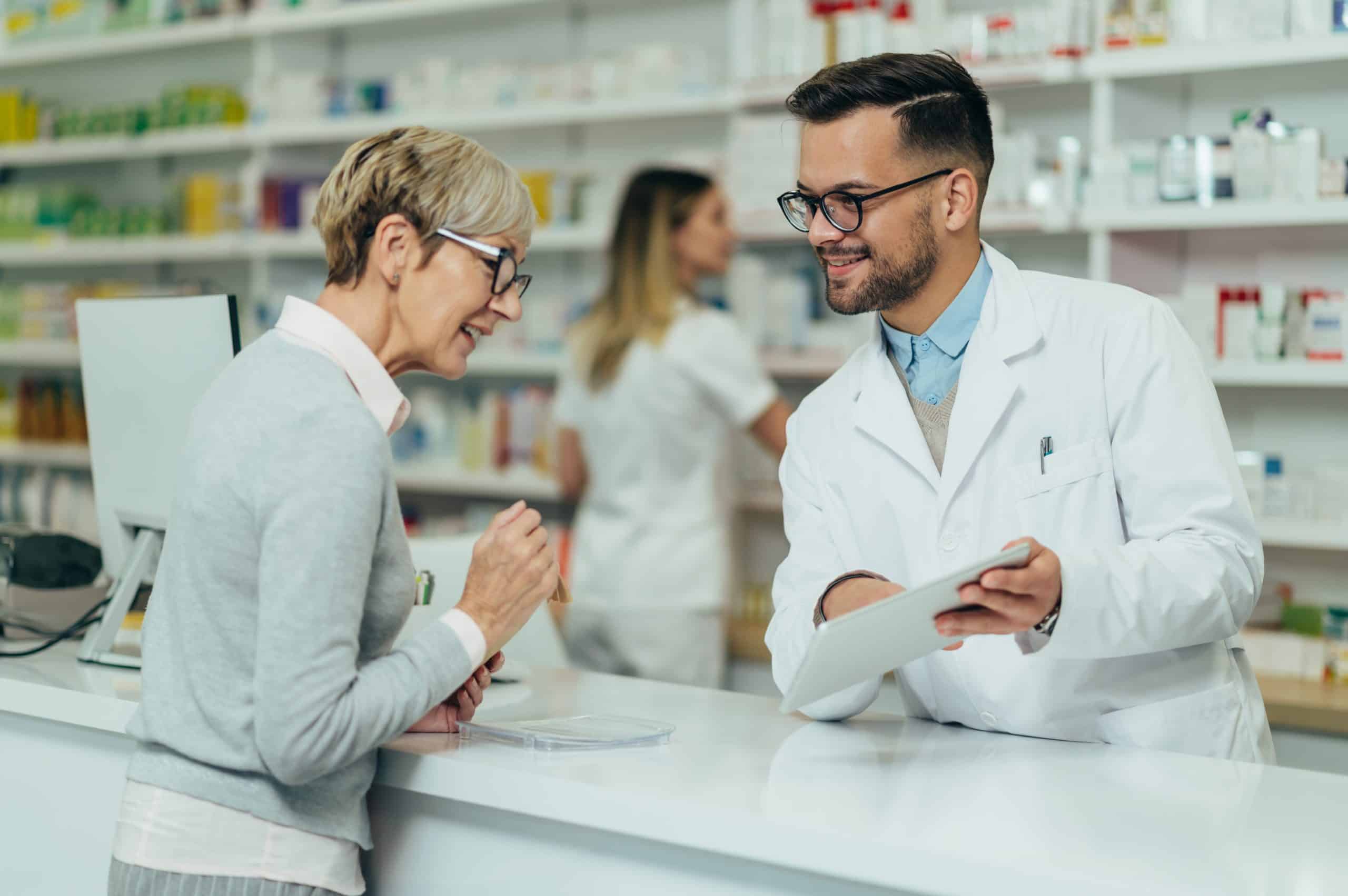 Female senior talking to male pharmacist