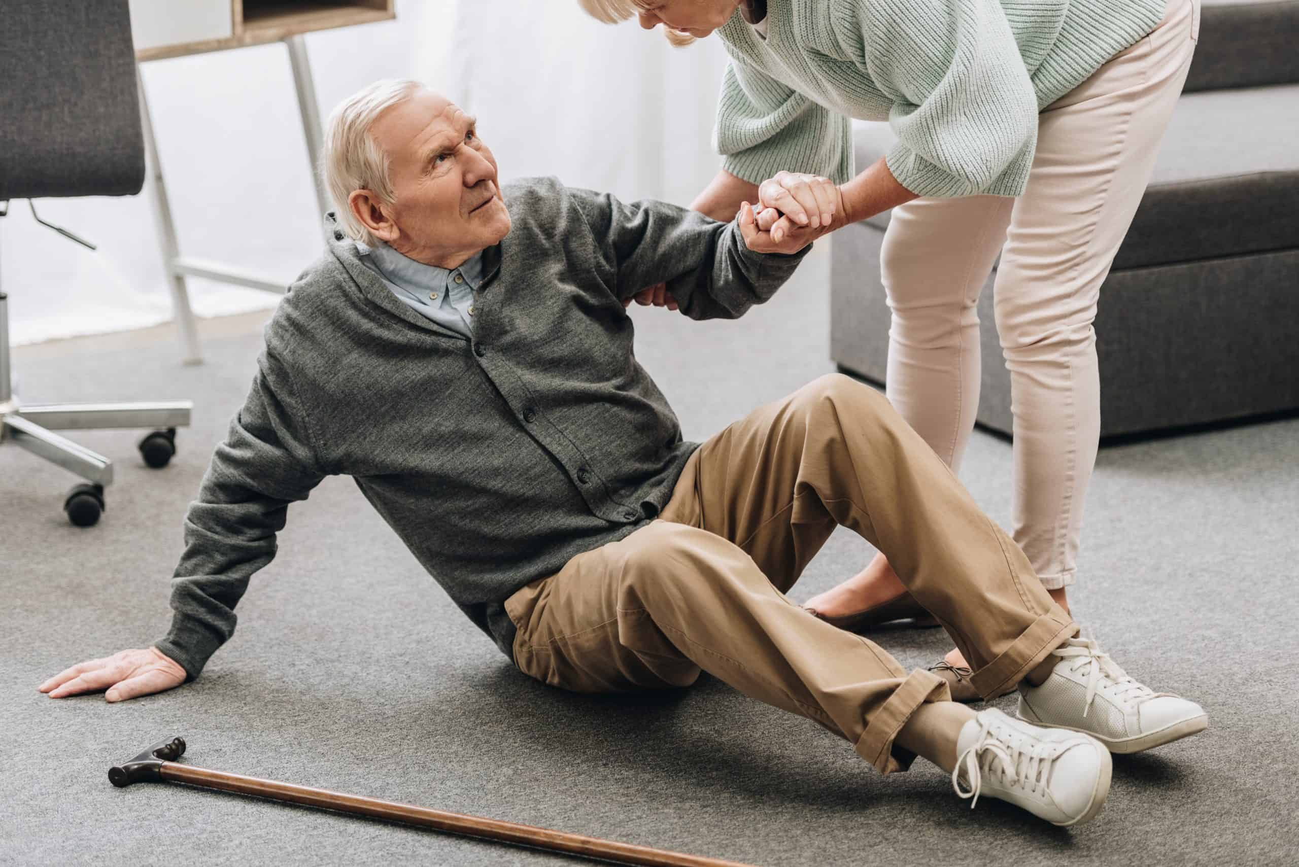 Woman helping man who has fallen down