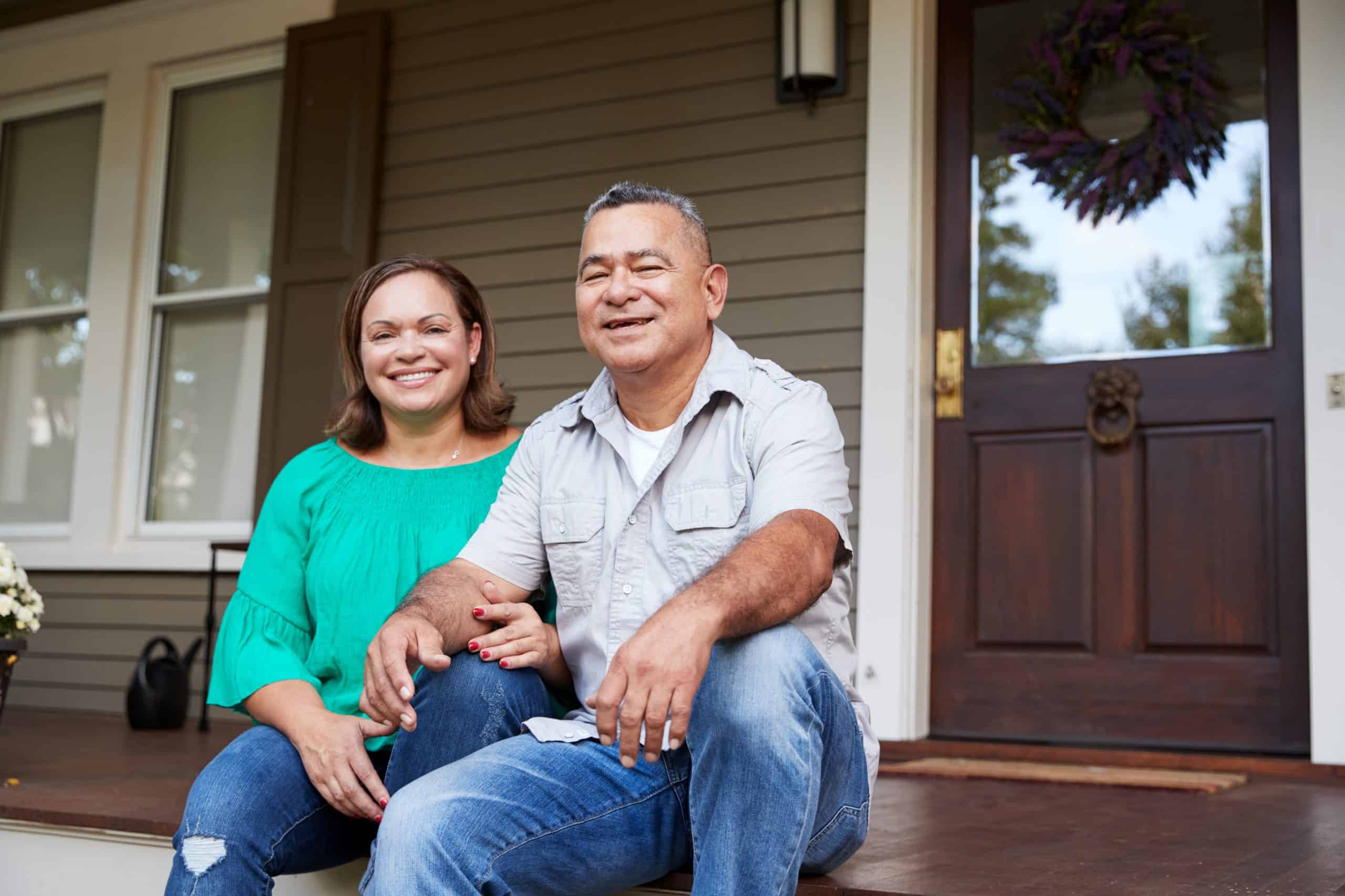 Man and woman sitting on front porch of house