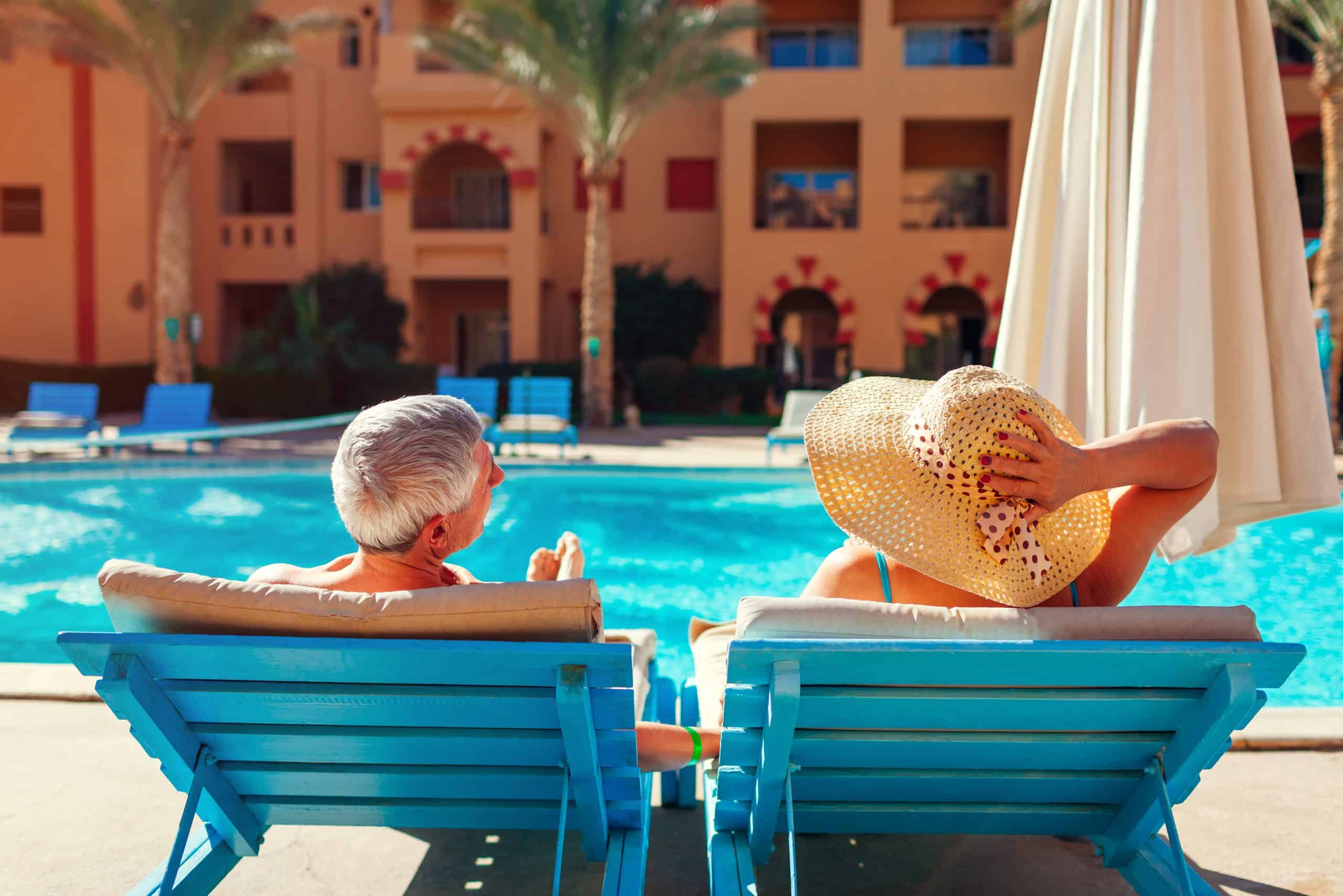 Couple sitting in chairs by a hotel pool