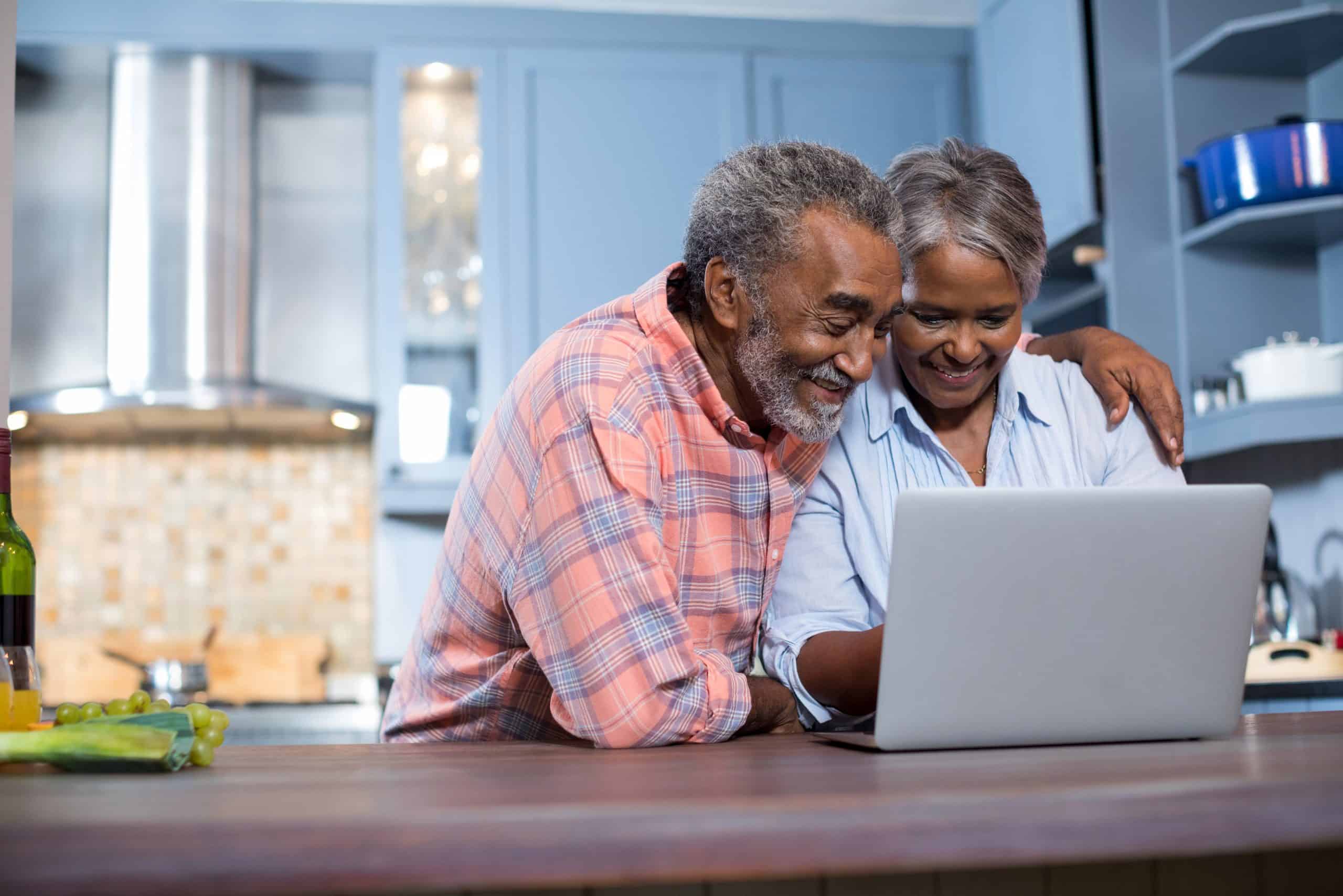 Smiling couple looking at a laptop