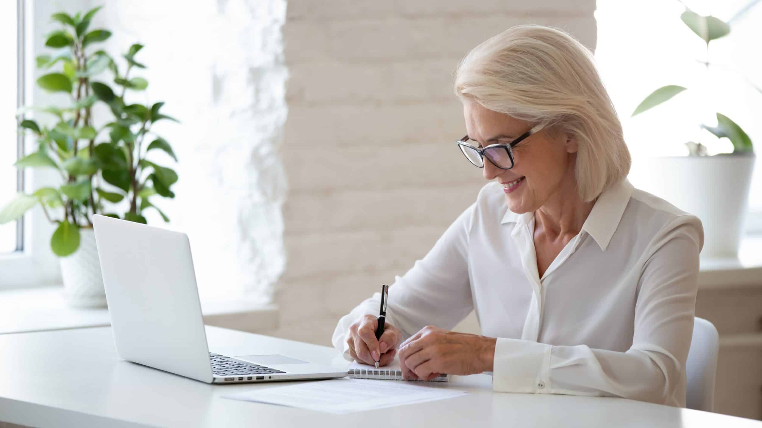 Woman in white blouse making a list to prepare for vacation