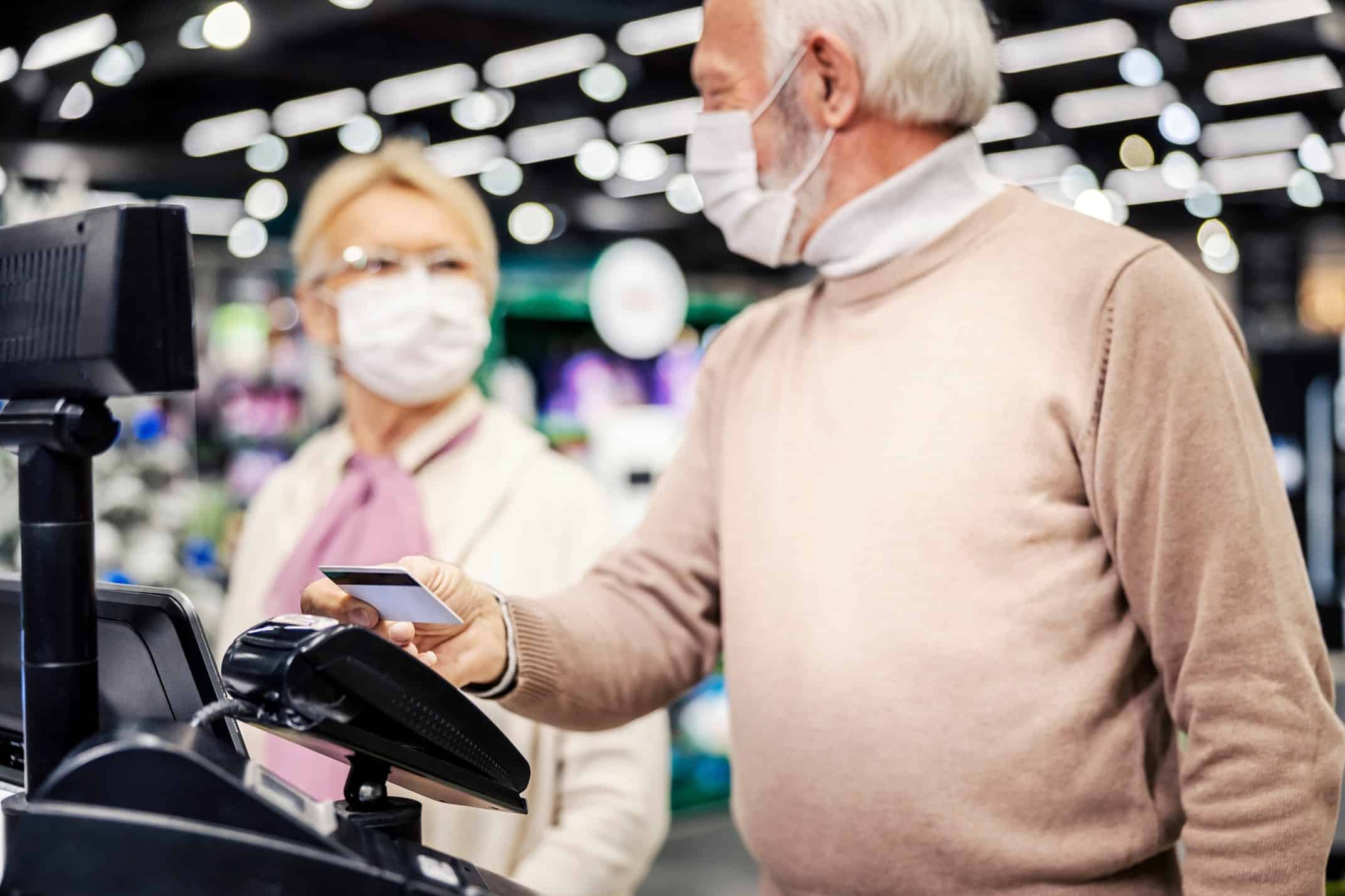 A man holding a credit card over a payment machine