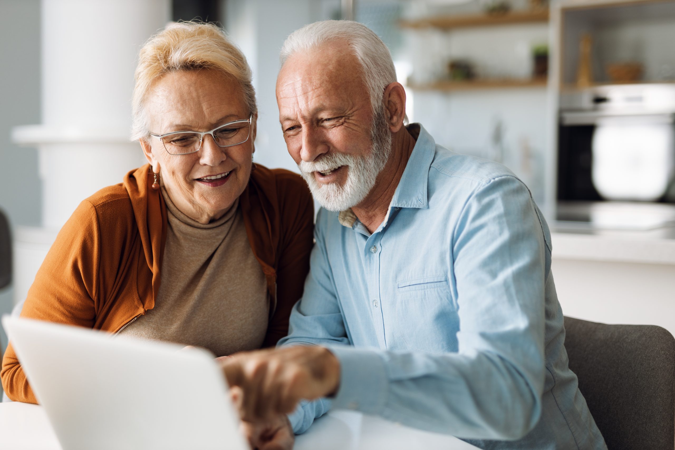 Woman and man using a laptop to book a vacation