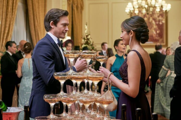 Movie still of a man and woman in front of glasses of champagne from Jolly Good Christmas
