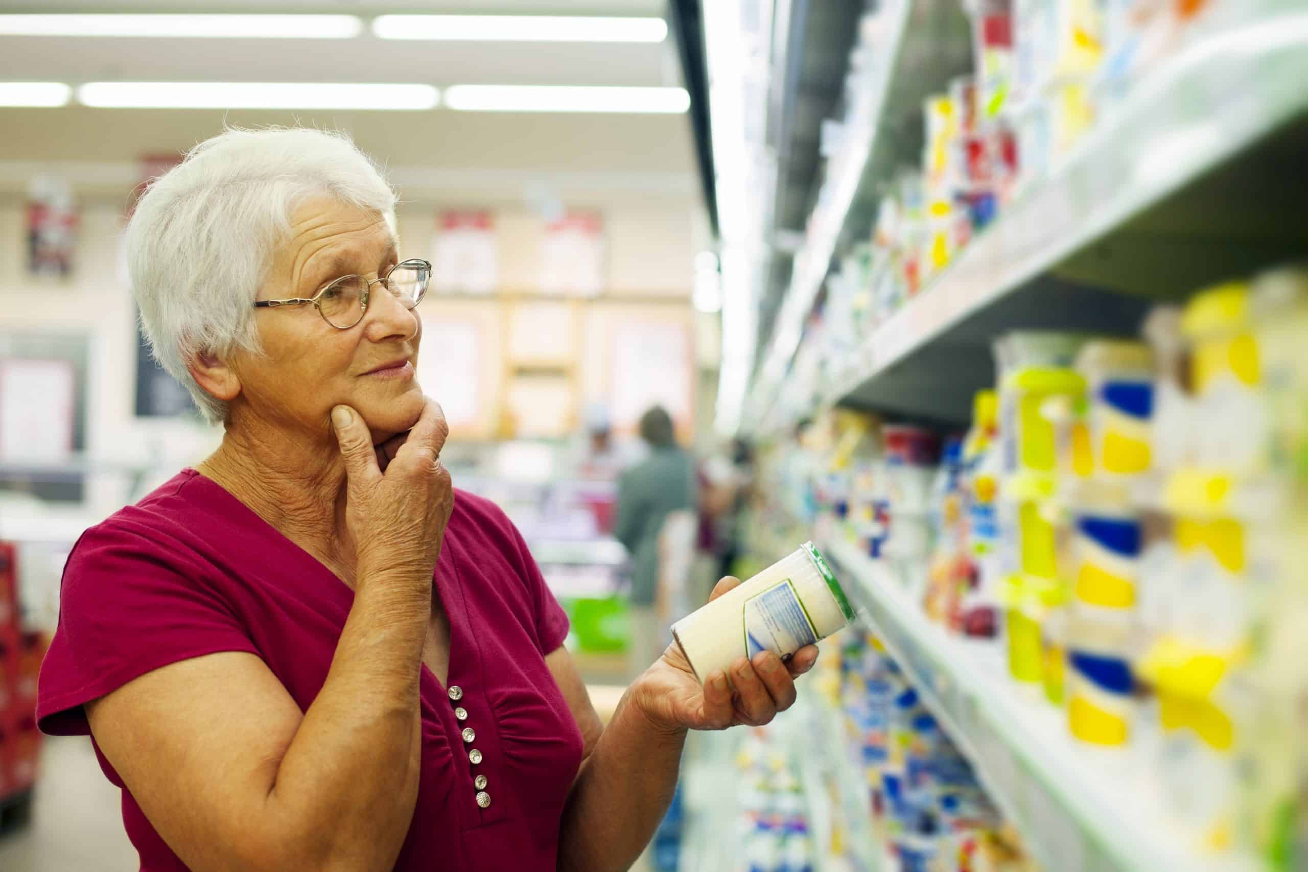 Woman looking at cans on shelf in grocery store