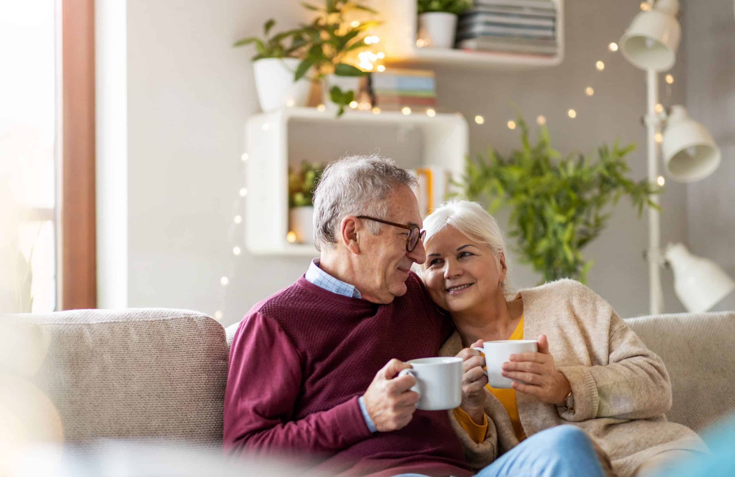 Senior couple holding white mugs