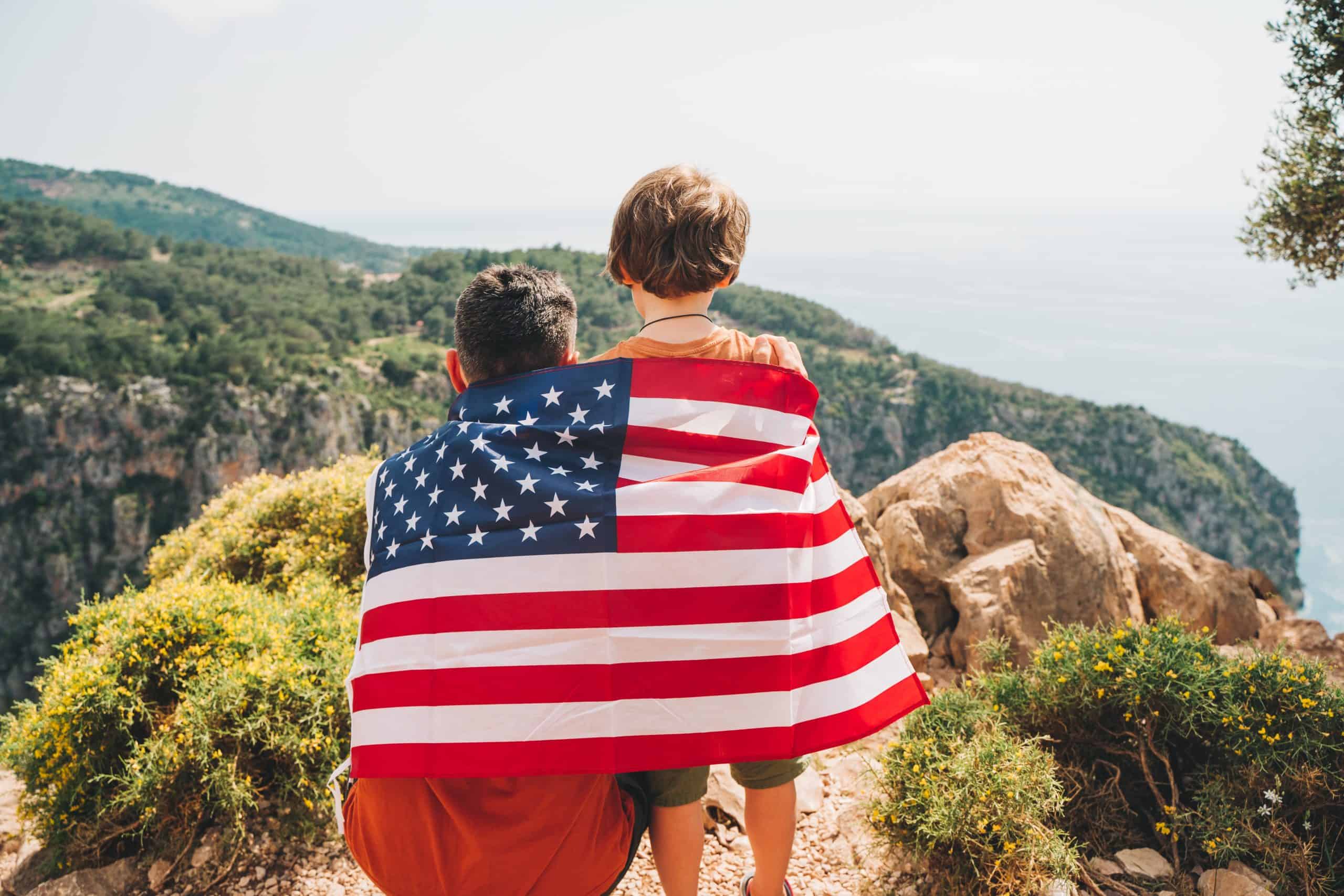 Two kids with an American flag wrapped around them