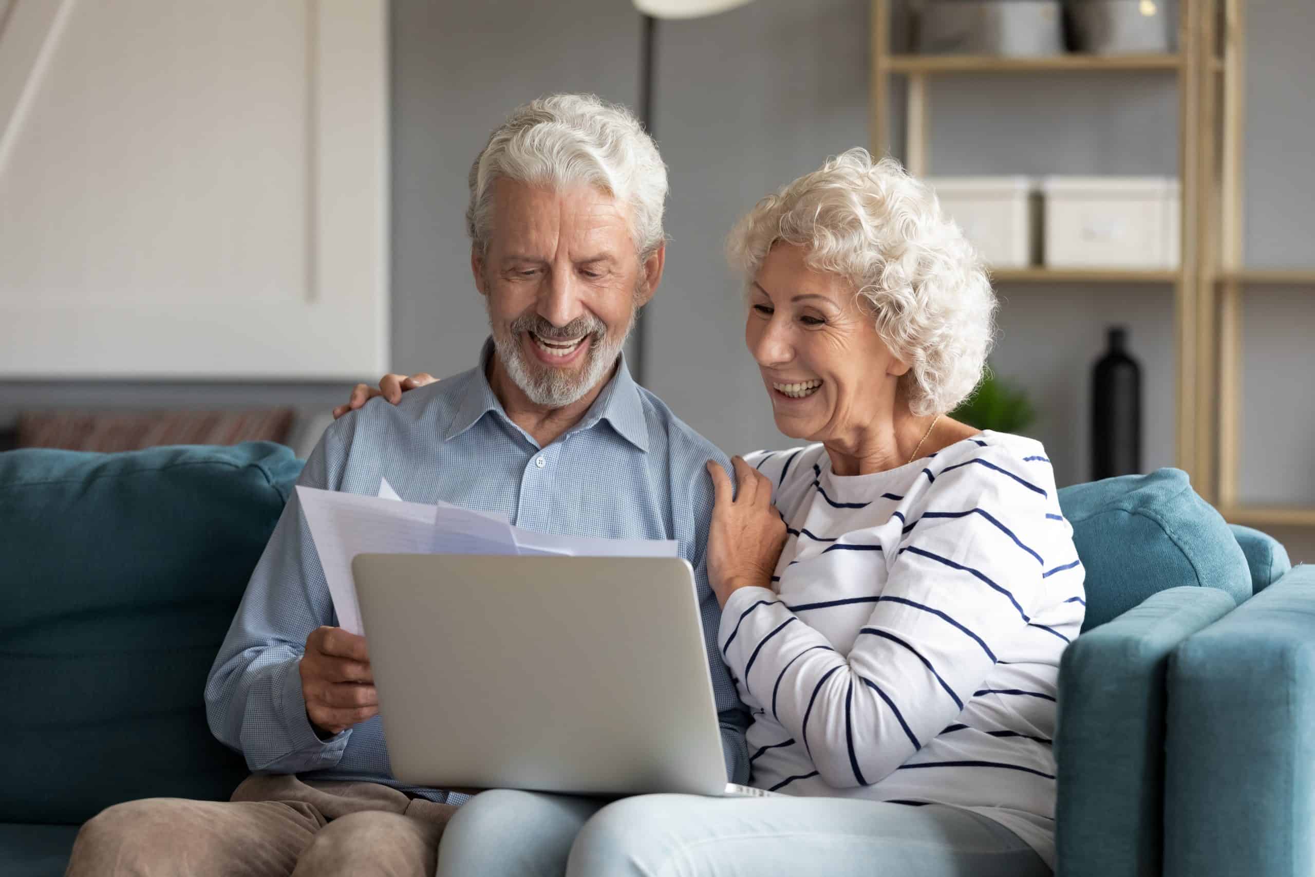 A couple looking a documents and a laptop