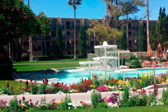 An outdoor garden, fountain, and pool at Fellowship Square Tucson.